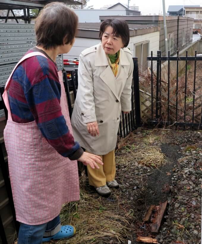 家が傾き、裏側の敷地が一部陥没した家屋の住人から詳しく事情を聞く吉岡弘子新市議補