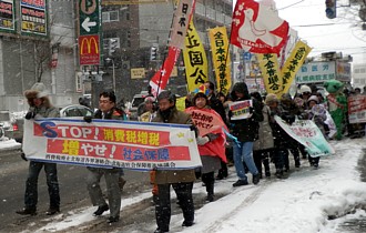 ひなさま、桃太郎を先頭に吹雪の中を行進する人たち。最前列中央は畠山和也候補