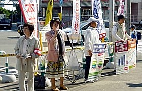 「増税強行に反対の声を」と通勤客に呼びかける吉岡さんと後援会員