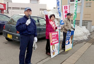 「安倍内閣の右傾化路線に自民党の身内からも懸念の声が」と話す松崎さんと、通勤客の激励に応える吉岡さん
