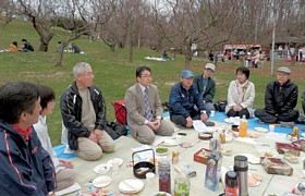 後援会の梅見会であいさつするはたやま和也さん（中央）と吉岡ひろ子さん（右から2人目）らの参加者