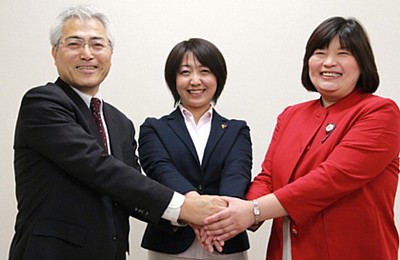がっちり握手する（左から）青山さん、池田さん、橋本さん