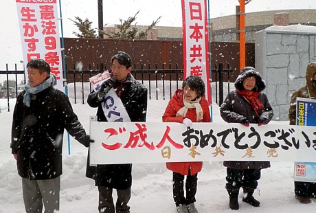 雪のなか成人式に参加する新成人への呼びかけを行う川部さん、吉岡さんと後援会員
