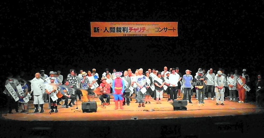 「新・人間裁判チャリティーコンサート」のステージで聴衆の拍手を受ける原告団、弁護団と出演ミュージシャン
