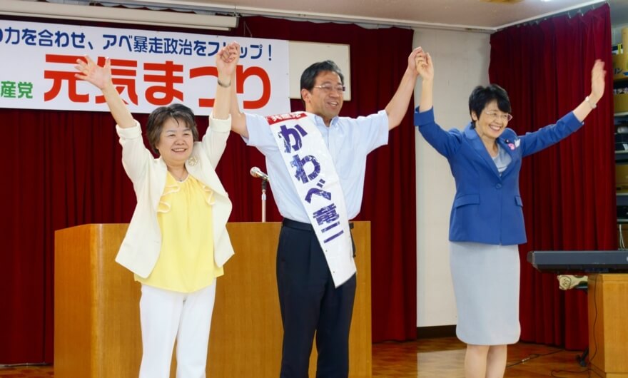 壇上で、参加者の声援にこたえる（右から）紙議員、川部さんと吉岡さん