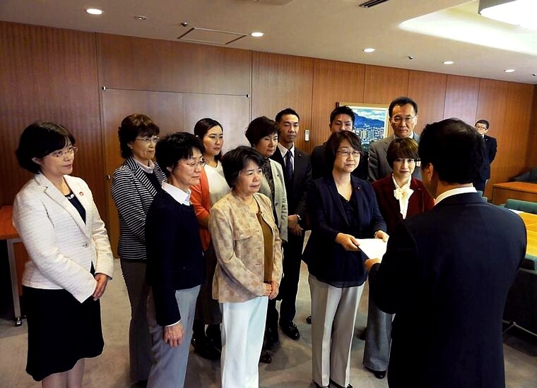 秋元市長（右）に要望書を渡す伊藤市議団長と各市議、吉岡さん（前列左から３人目）と市議候補予定者ら