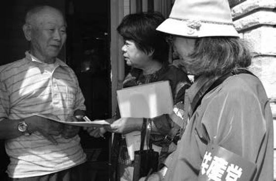 『諸制度活用の手引き』を手渡し要望を聞く吉岡さん（中央）と清田区委員会の女性（右）