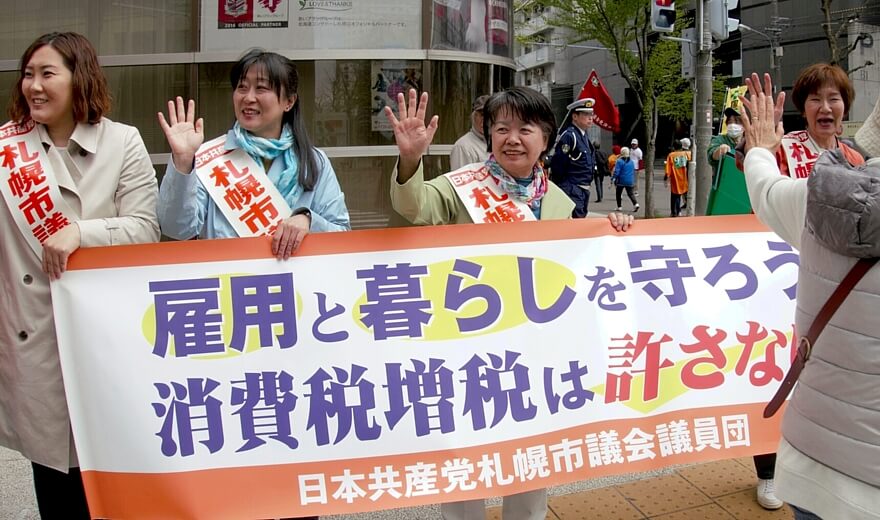 沿道でメーデー行進参加者を激励する吉岡弘子市議（中央）ら日本共産党の札幌市議