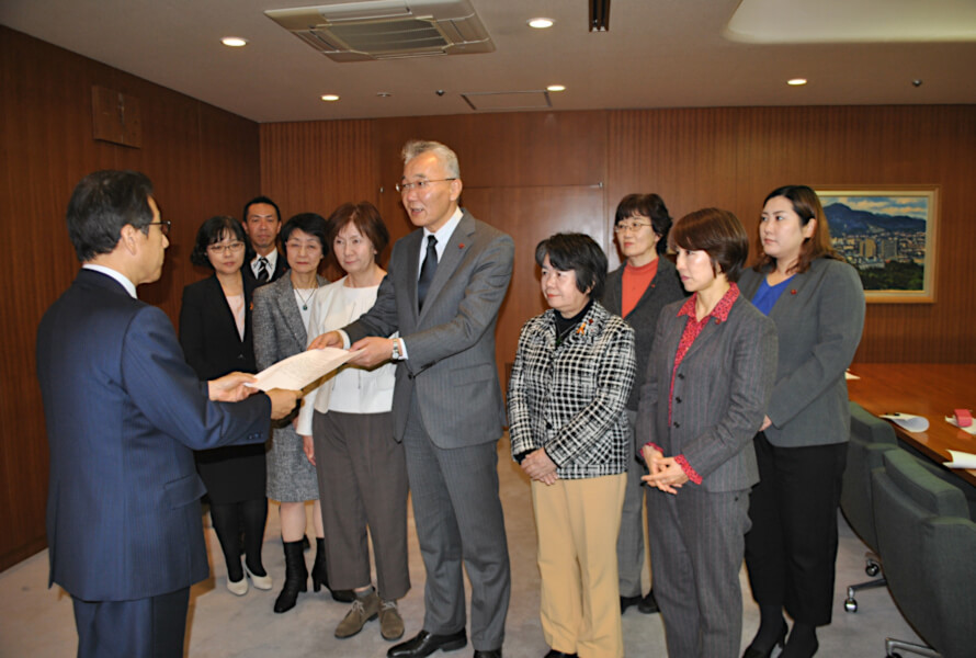 秋元市長（左）に要望書を手渡す村上団長と清田区選出の吉岡弘子市議（前列右から2人目）ら党市議団